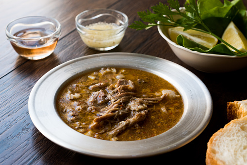 Turkish Soup Beyran with Lamb Meat, Rice, Chopped Garlic and Vinegar Sauce Served with Salad. Traditional Organic Food.