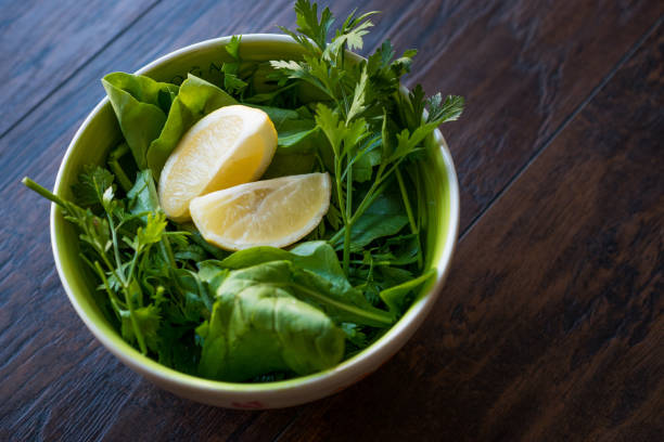 Fresh Parsley and Arugula / Rucola or Rocket Leaves with Lemon in Ceramic Bowl.