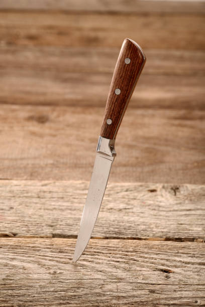 istock Kitchen knife stuck in the wooden table 1034886770