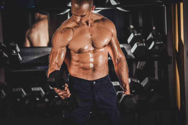 istock Muscular man exercising with dumbbells 1034887626