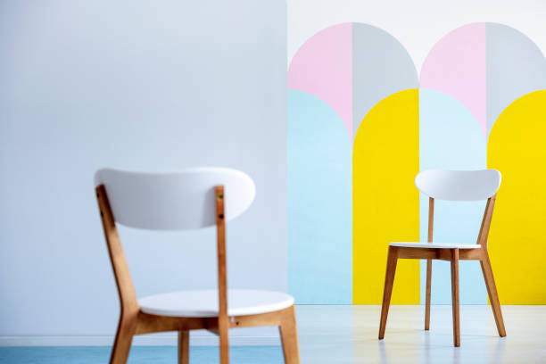 istock Two white chairs facing each other in a bright office interior with pastel decorations. Real photo with blurred foreground 1034887938