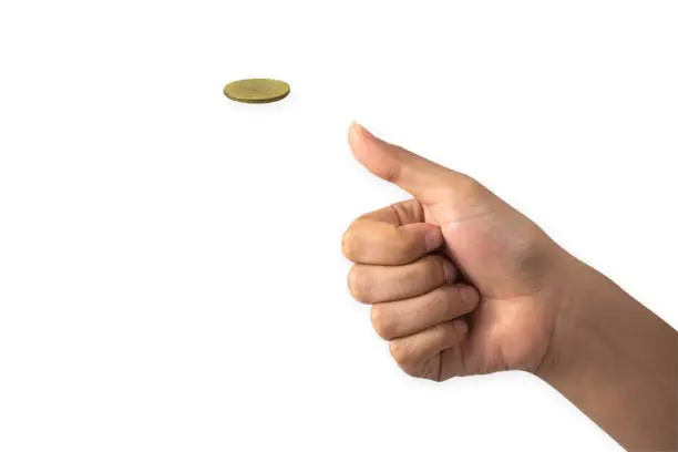 Photo of Hand of businessman tossing a golden coin isolated on white background