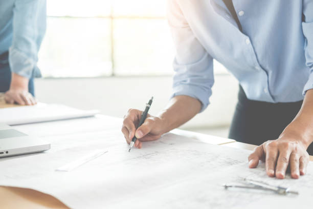 istock Midsection Of Architect Working On Blueprint At Office 1034893026