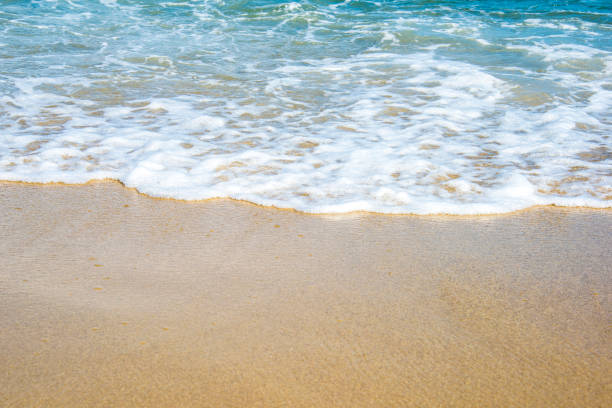 istock Soft wave of ocean on the sandy beach 1034894318