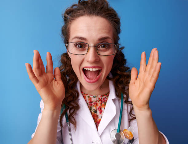 istock happy paediatrician doctor playing peekaboo on blue 1034895486