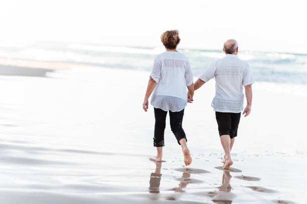 istock happiness senior couple walking togetherness on the beach 1034896000