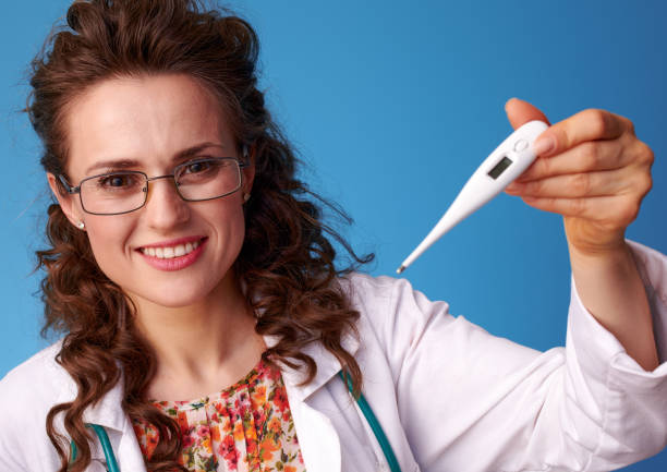 happy pediatrician woman showing thermometer on blue - 13417 imagens e fotografias de stock