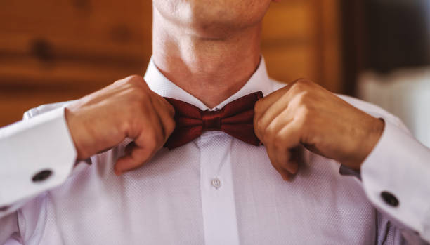 istock Close up of mans hands making his ribbon looking good before celebration. 1034898700