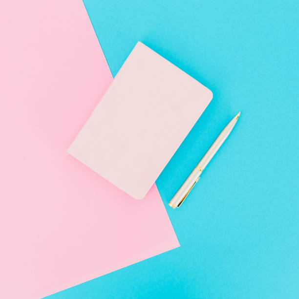 istock Diary with silver pen on blue and pink background. Flat lay. Top view 1034905480