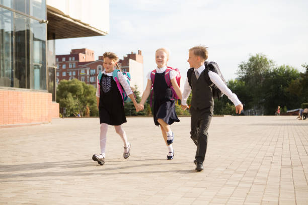 group of little school kids going to school together. - smiling little girls little boys autumn imagens e fotografias de stock