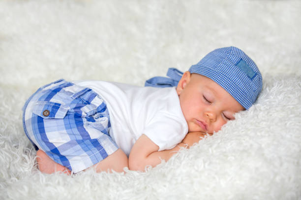 istock Cute baby boy, sleeping in bed with hat 1034918596