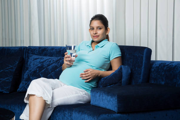 istock Pregnant woman drinking water - Stock image 1034918726