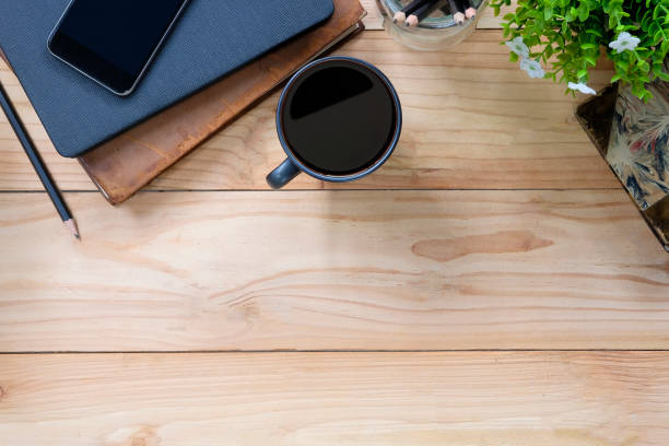 istock Office desk a coffee, book, pencil and smartphone on copy space workspace table top view with wood texture. 1034919012