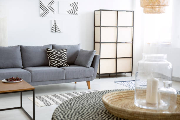 istock Patterned cushion on grey sofa next to screen in modern flat interior with posters. Real photo 1034920378