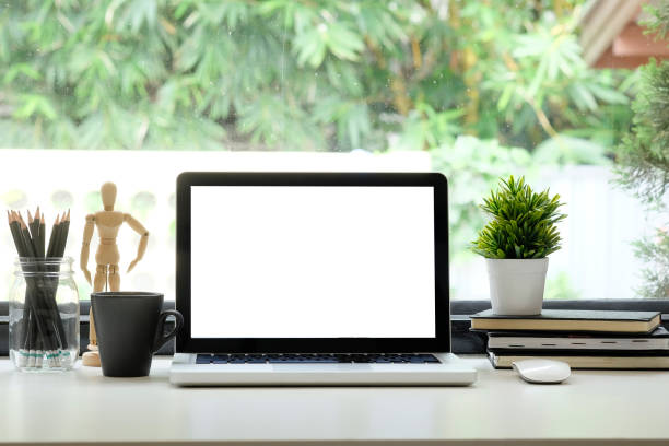 istock Workspace laptop computer, coffee, pencil and plant decoration with big window and nature on background. 1034925718