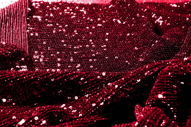istock Texture, background, pattern, red fabric with paillettes. Look at these neon red sequins. Round neon pink sparkles glitter overlapping iridescent glitter on a clean purple grid. 1034928866