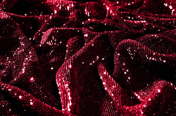 istock Texture, background, pattern, red fabric with paillettes. Look at these neon red sequins. Round neon pink sparkles glitter overlapping iridescent glitter on a clean purple grid. 1034928888