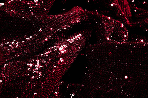 istock Texture, background, pattern, red fabric with paillettes. Look at these neon red sequins. Round neon pink sparkles glitter overlapping iridescent glitter on a clean purple grid. 1034929184