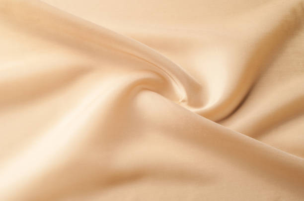 istock Texture background of fabric. Beige fabric. Silk fabric wallpaper texture background pattern in sepia pastel yellow cream beige tint: Lovely natural silk textured textile 1034931080