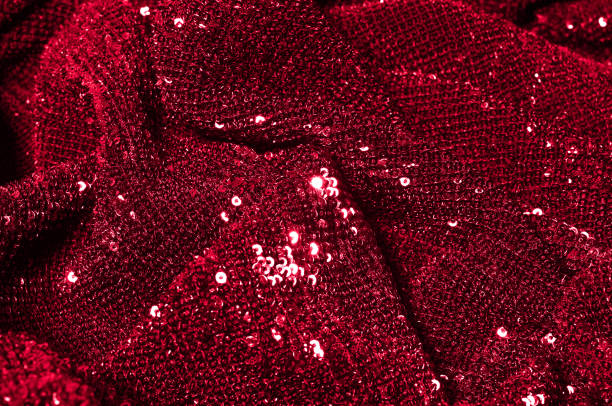 istock Texture, background, pattern, red fabric with paillettes. Look at these neon red sequins. Round neon pink sparkles glitter overlapping iridescent glitter on a clean purple grid. 1034931370