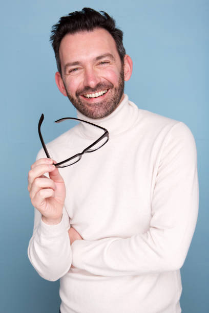 istock happy man posing against blue background with glasses 1034931442