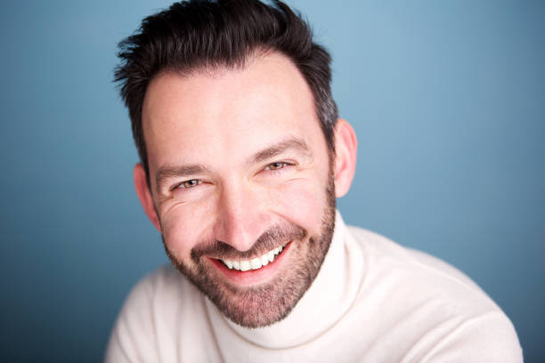 istock Close up happy man with beard posing against blue background 1034931464