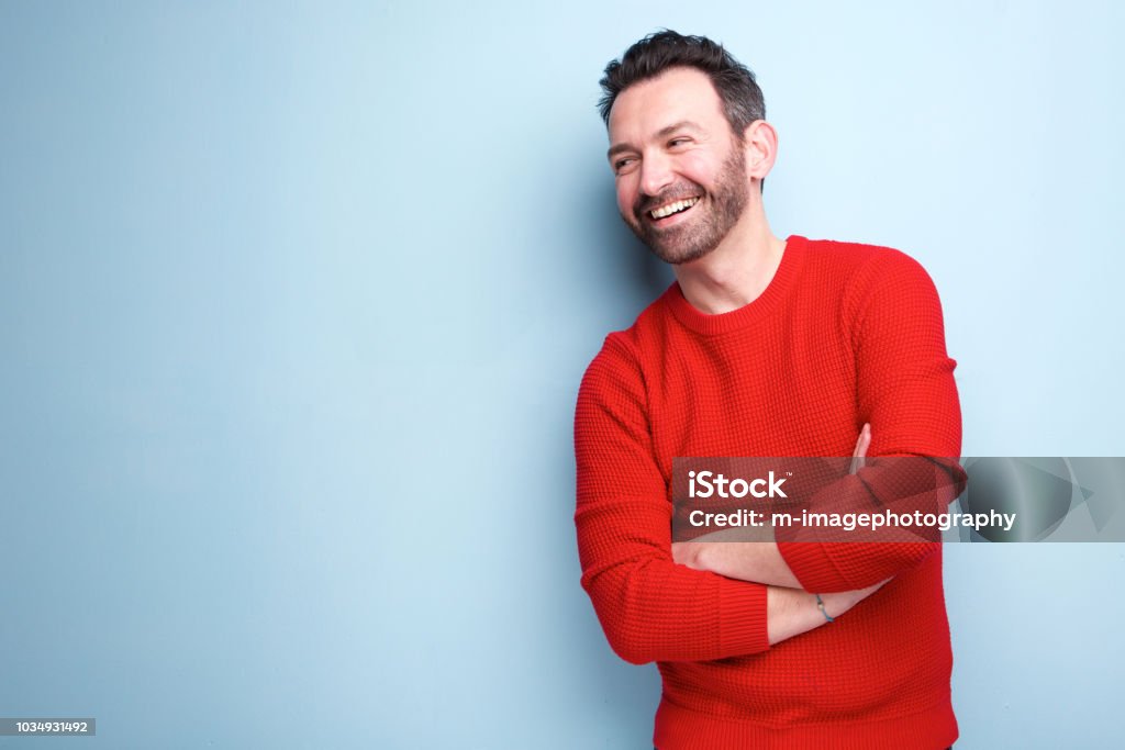 fröhlicher Mann mit Bart lachend vor blauem Hintergrund - Lizenzfrei Männer Stock-Foto