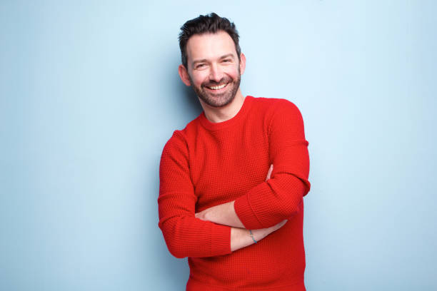 cheerful man with beard posing against blue background stock photo