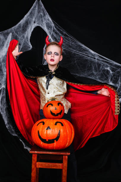 istock A young boy in halloween devil costume with pumpkins having fun 1034945452
