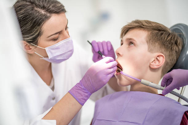 젊은 남성 환자 치아 충전을 주는 여성 치과 의사 - dental equipment dental drill dentist surgical mask 뉴스 사진 이미지