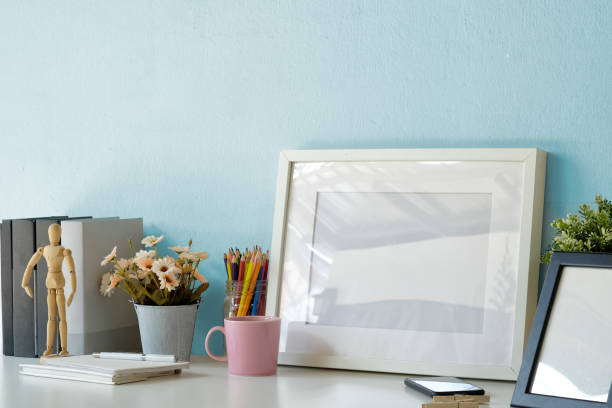 istock Mockup workspace table with white poster frame, coffee mug, notebook and supplies. 1034962496