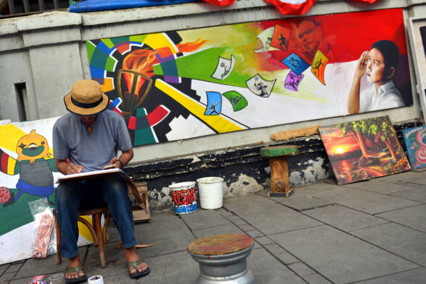 Streetartist painting colorful paintings on a sunny day in Jakarta, Indonesia