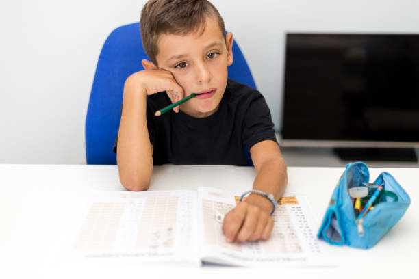 istock Sad boy struggles to finish his homework 1034969912