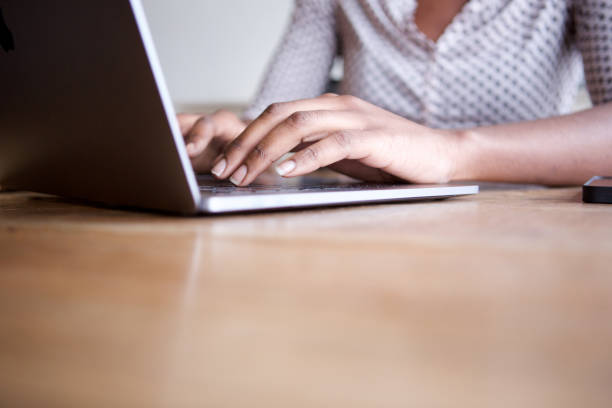 istock Close up partial woman sitting and typing on laptop computer in home office 1034985638