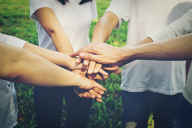 istock Midsection Of Friends Stacking Hands While Standing At Park 1034986344
