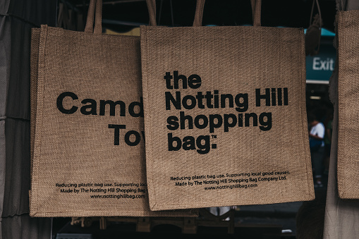 London, UK - July 21, 2018: Jute bag by The Notting Hill Shopping Bag Company on sale at Portobello Road Market. Its images designed by local artists and benefit and promote Notting Hill.