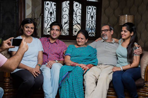 istock Happy family sitting on couch at home - Stock image 1034993482