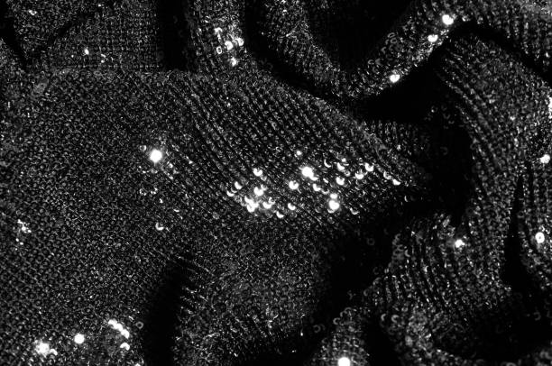 istock Black fabric with paillettes Make a dazzling debut  this Black Baby Sequined  The coating of the strength of the continuous mesh remains a dense arrangement of circular glitters for the entire coating 1035005100
