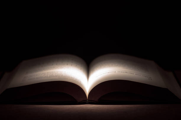 istock Close-Up Of Open Book On Table Against Black Background 1035006104