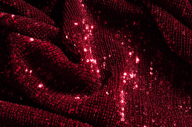 istock Texture, background, pattern, red fabric with paillettes. Look at these neon red sequins. Round neon pink sparkles glitter overlapping iridescent glitter on a clean purple grid. 1035006774