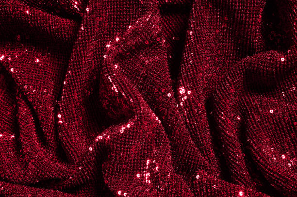 istock Texture, background, pattern, red fabric with paillettes. Look at these neon red sequins. Round neon pink sparkles glitter overlapping iridescent glitter on a clean purple grid. 1035007830