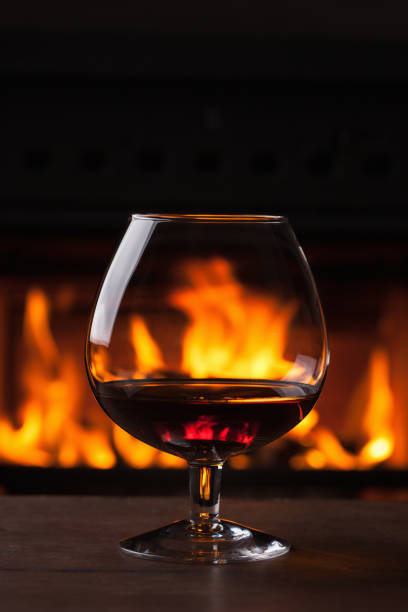istock a glass of cognac in front of fireplace 1035008078