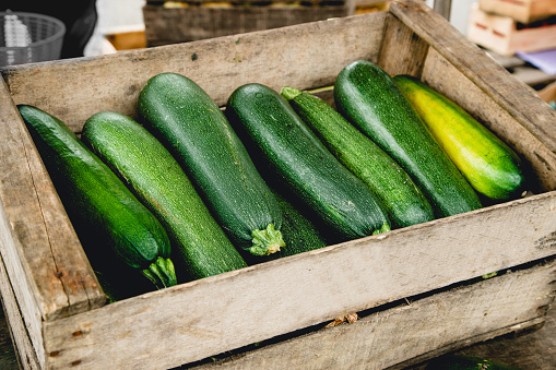 Zucchinis in wooden box at the market