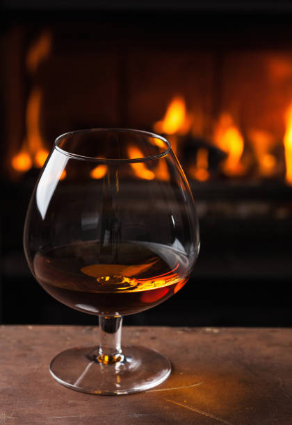 istock a glass of cognac in front of fireplace 1035011230