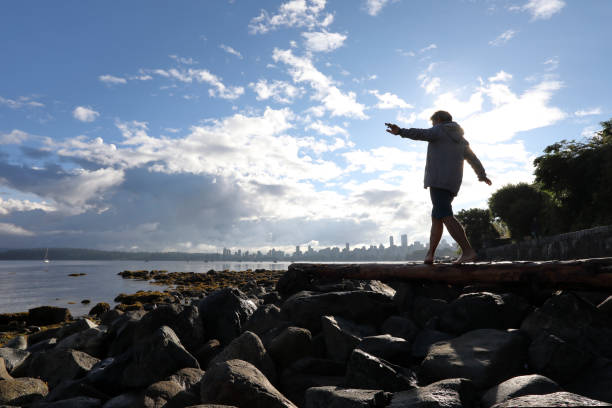istock Man balances on log by the beach 1035011374