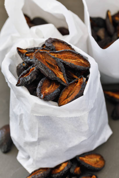 istock Fresh prunes packaged on several paper bags, close-up 1035017368