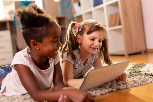 istock Little girls playing video games on a tablet computer 1035020392