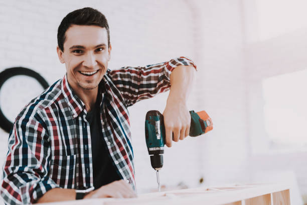 istock Young Man Assembling Wooden Bookshelf at Home. 1035021786