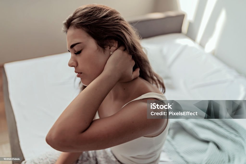 This is so Painful! This Is So Painful! Young Woman Sitting on the Bed With Pain in Neck. People With Body-muscles Problem, Healthcare and Medicine Concept Chronic Illness Stock Photo