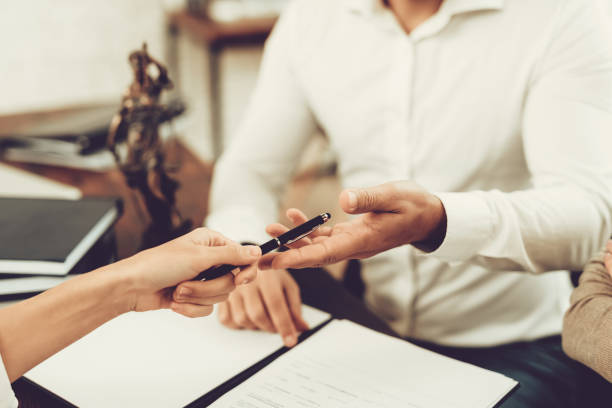 istock Husband and Wife Signing Documents with Lawyer. 1035026266